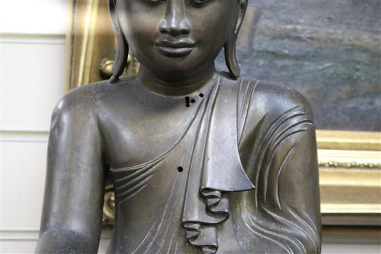 A 19th century Burmese bronze Buddha inset ebony and ivory eyes seated on bespoke lotus-carved polished wood column